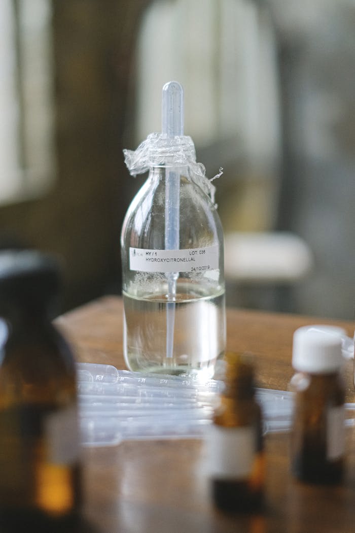 Glass bottles with liquid in a laboratory setting, featuring selective focus and blurred background.